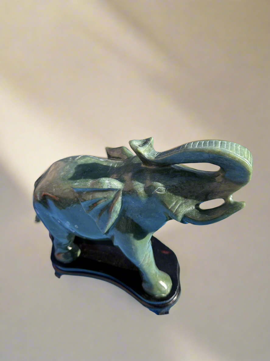 This is a hand-carved Nephrite jade sculpture depicting happy elephant, complete with the artist's signature.